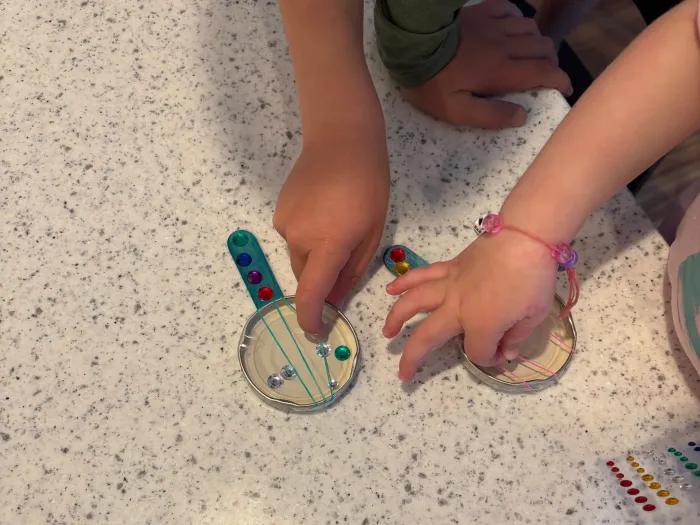 children moving the loom bands secured across jar lid