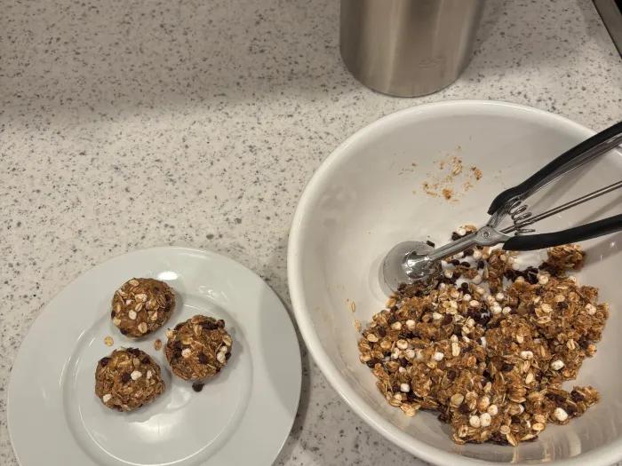 bowl with plate next to it with scoops of granola mixture on it
