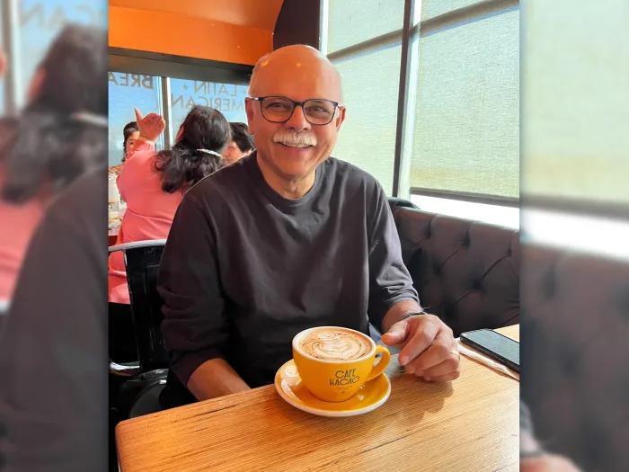 man smiling with glasses in booth