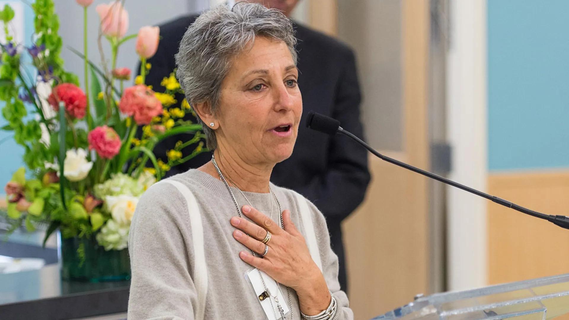 woman at mic. with hand over her heart