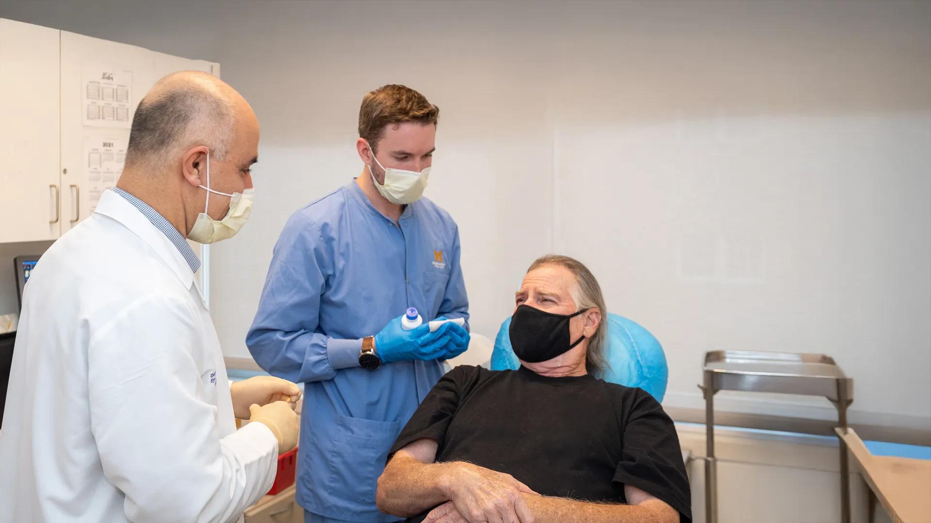 Dr. Hakan Demirci with a patient in an exam room