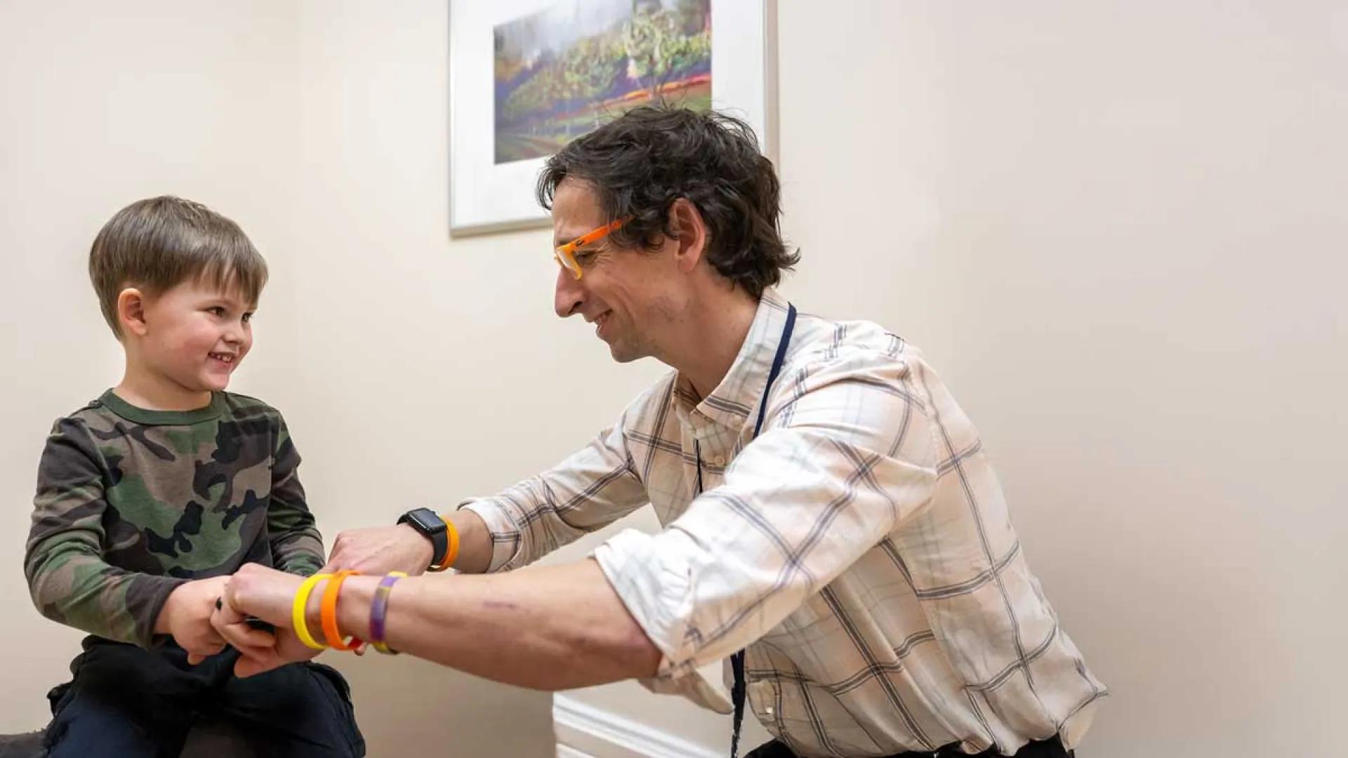 A doctor examples the strength of a child's hands.