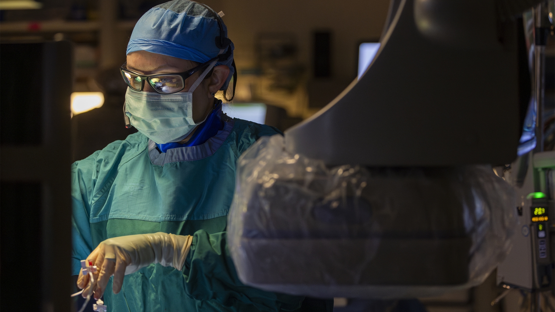 Female surgeon gowned and masked performing surgery