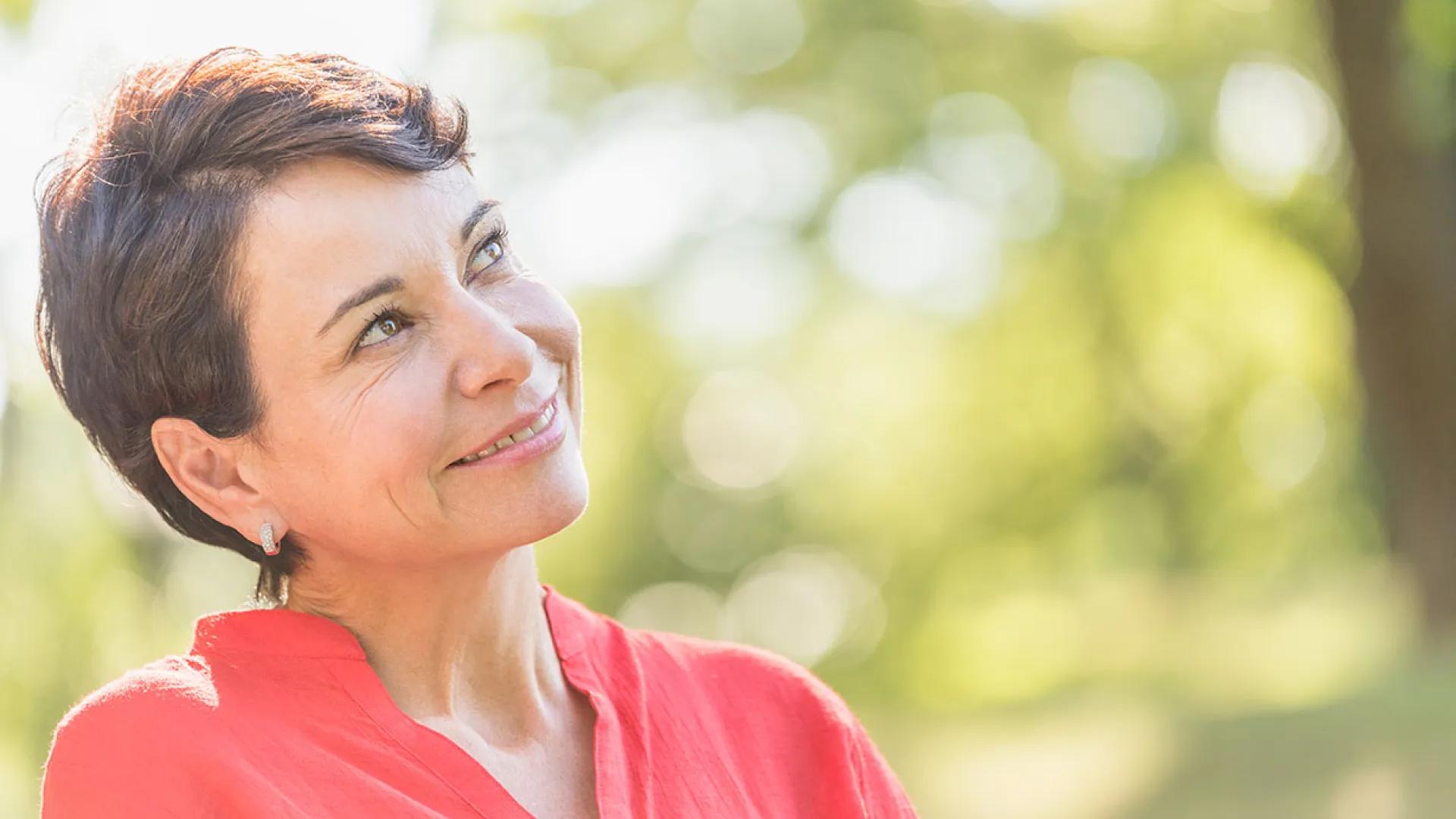 Older woman looks up at sunshine