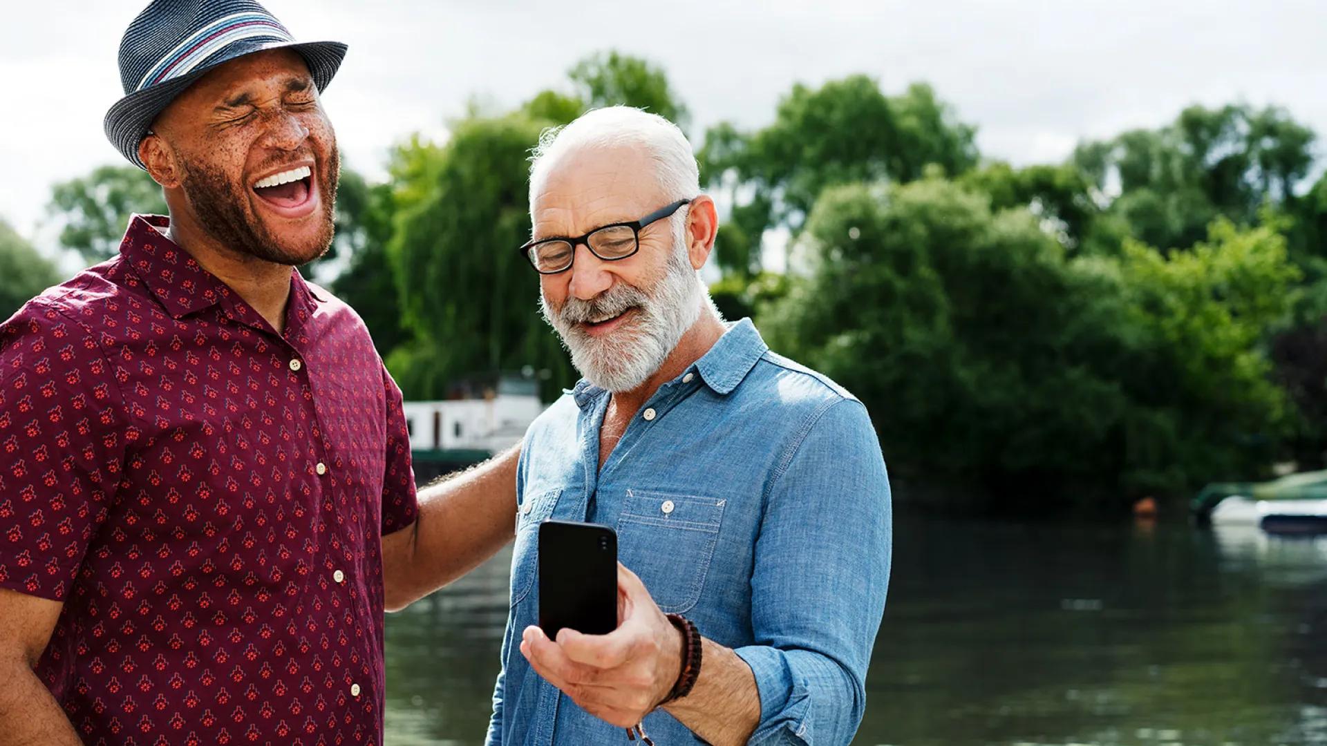 Older black man laughs with older white man
