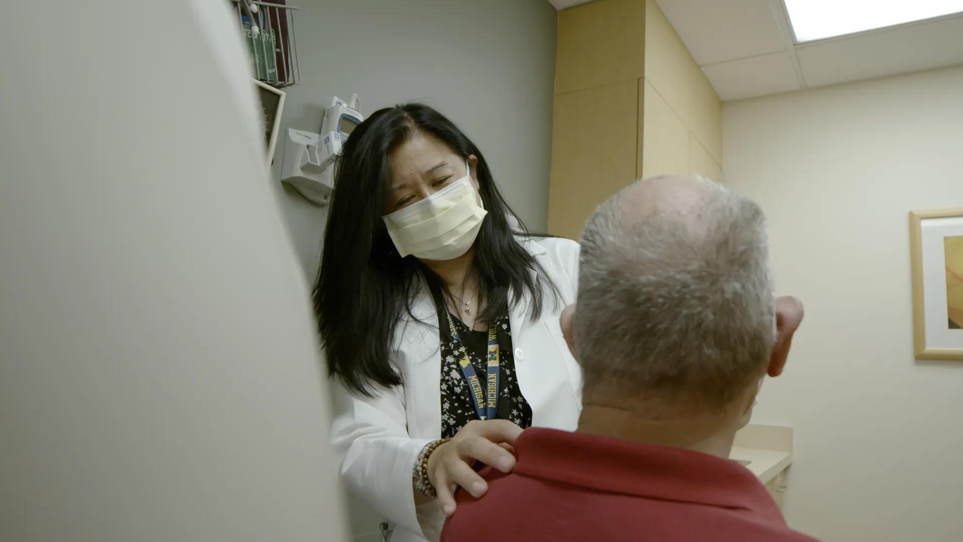 Female doctor tends to elderly patient in clinic room