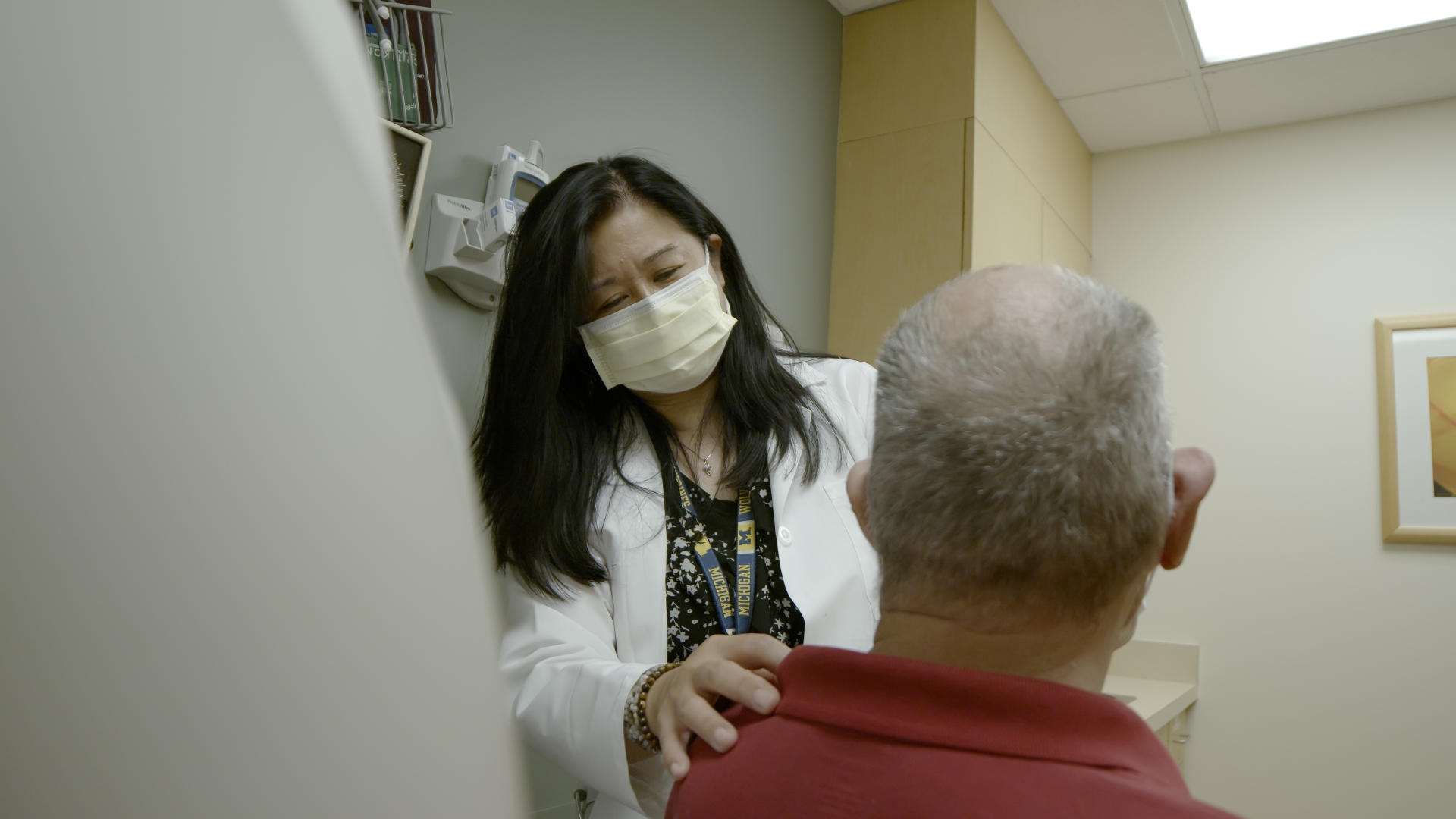 Female doctor tends to elderly patient in clinic room