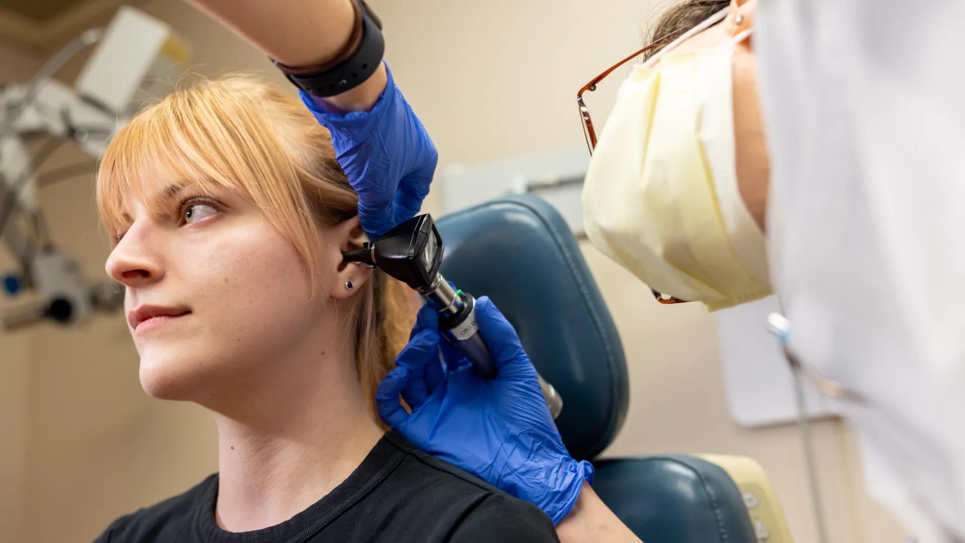 young woman gets ear checked at doctor
