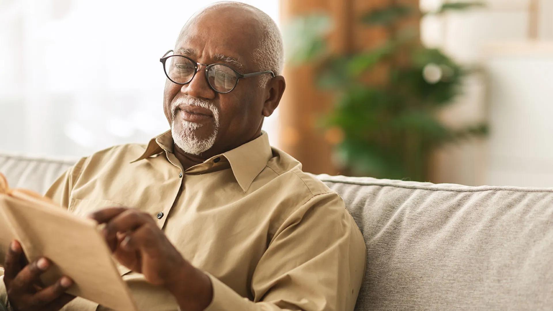 Older Black man reads a book