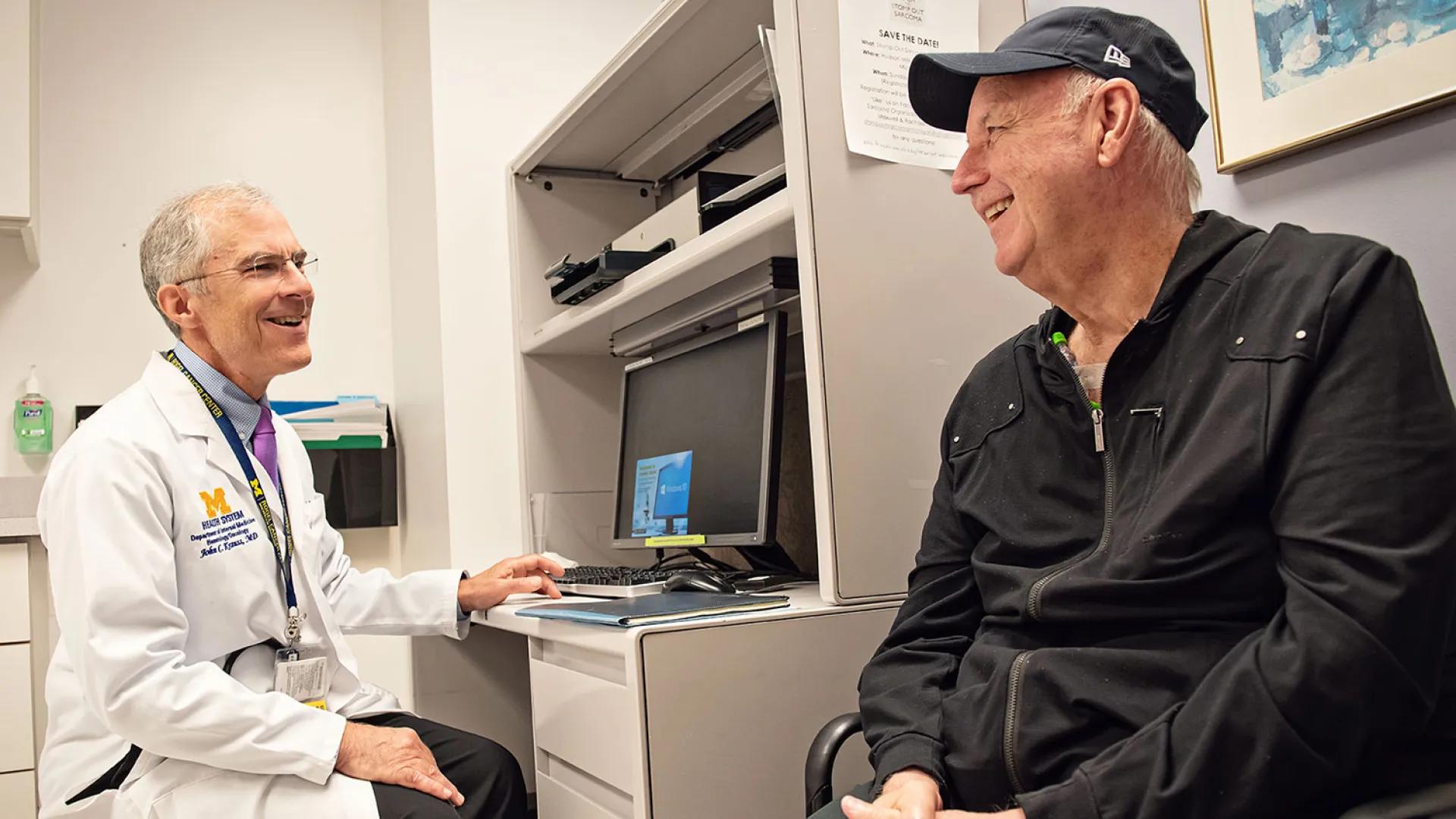 Dr. John Krauss talks with a male patient in the clinic