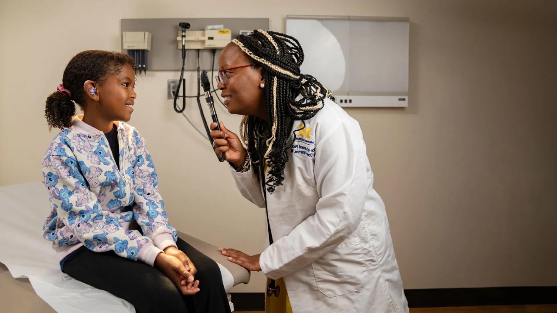female pediatrician examines a young girl patient