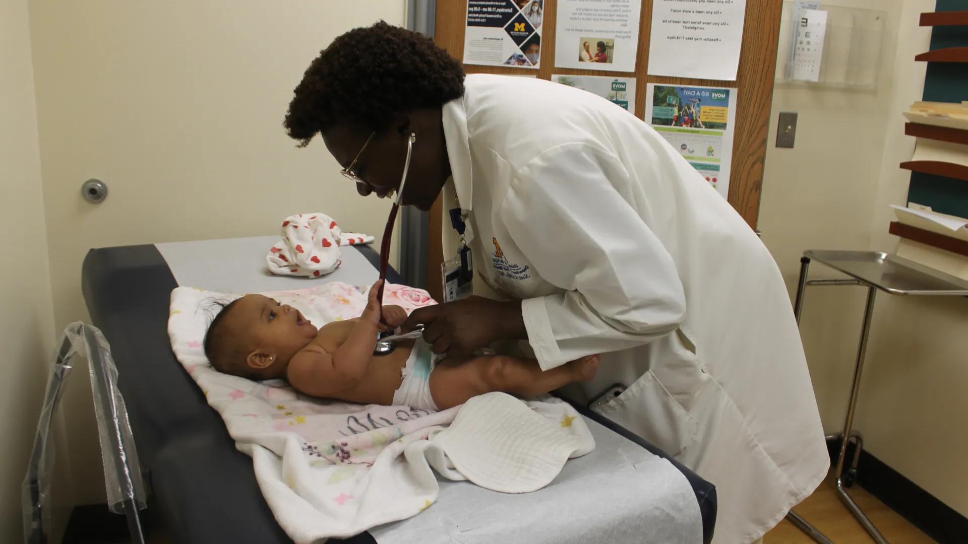 doctor examines baby on table