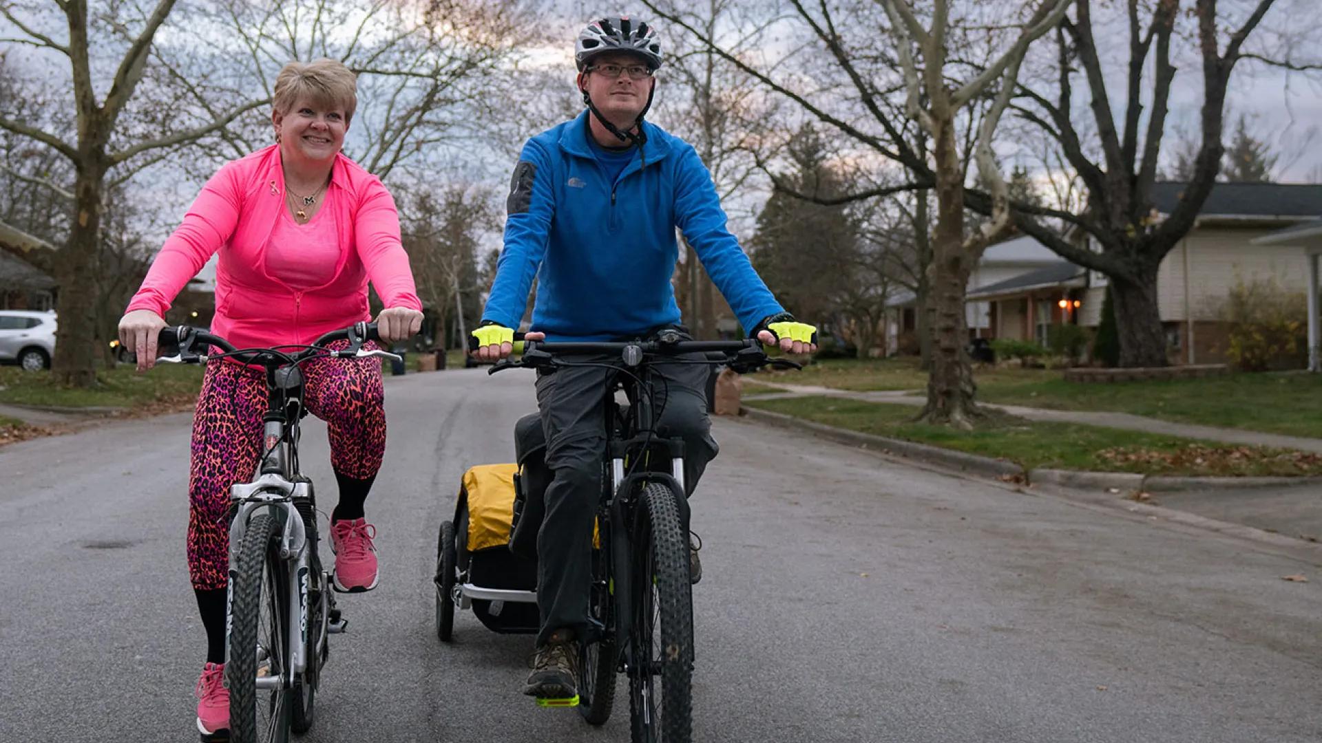 Man and woman riding bicycles through their neighborhood