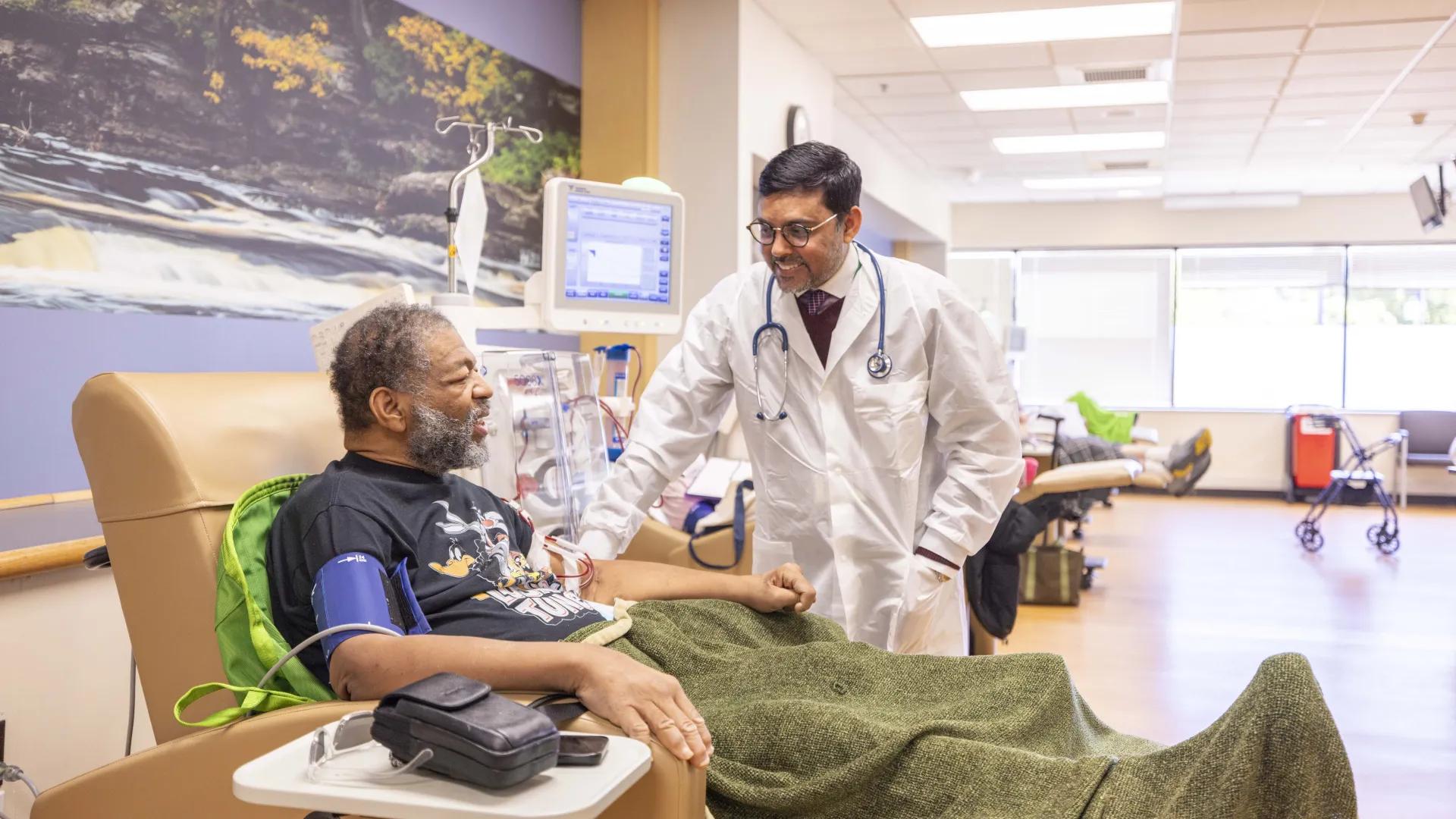 Provider checks on male patient receiving dialysis