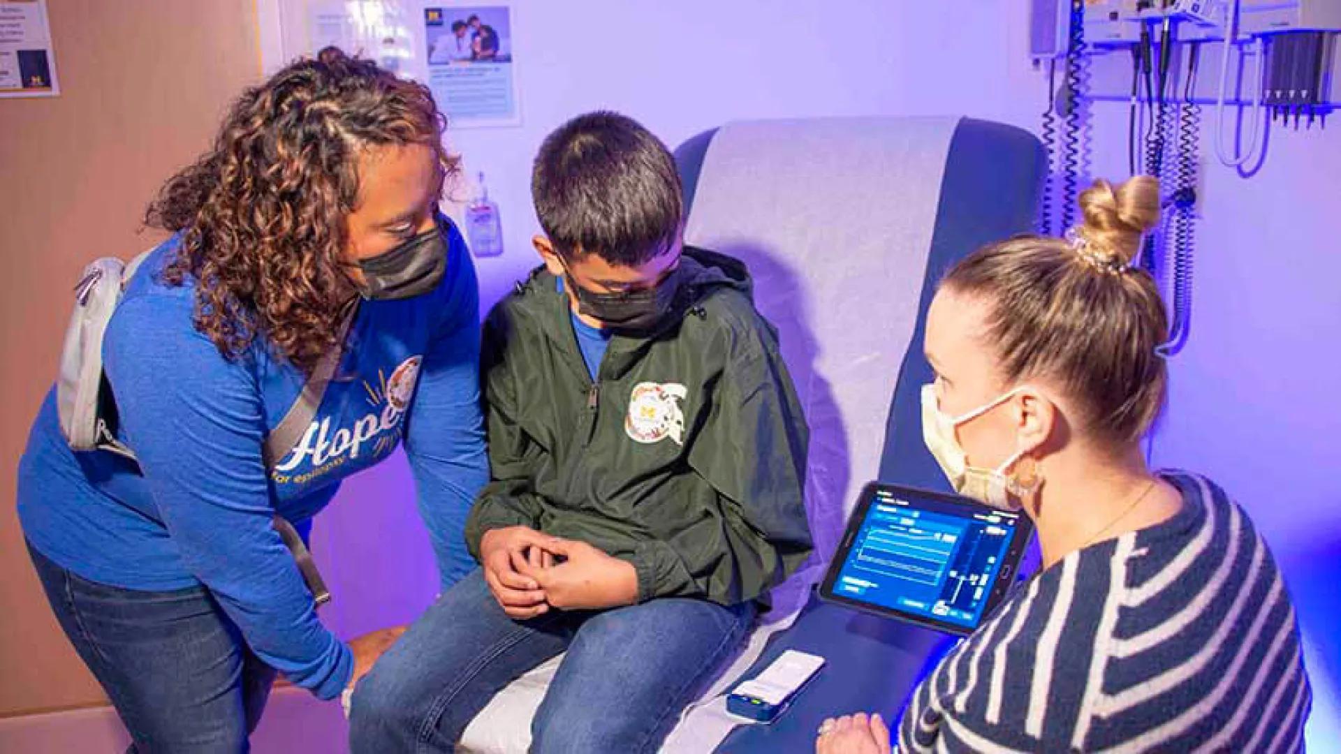Mom and patient with doctor viewing brain waves