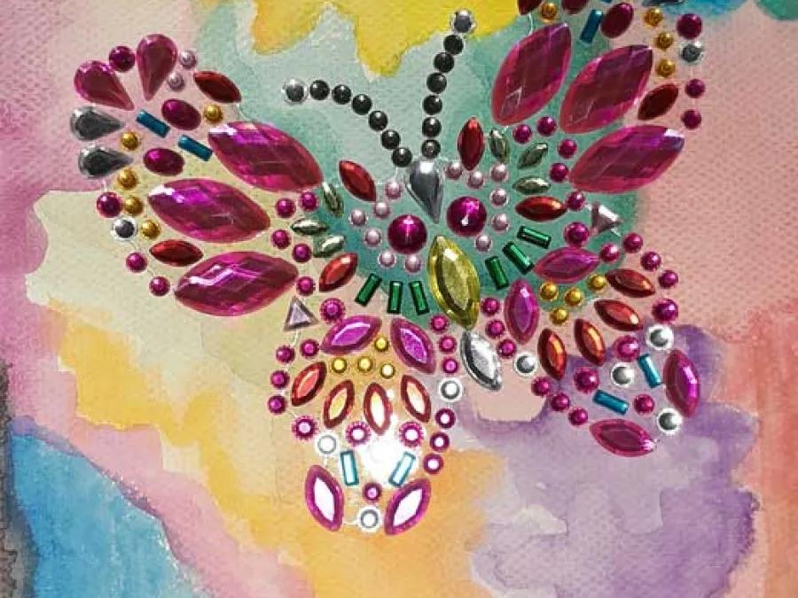 Watercolor background with colorful, beaded butterfly in the foreground