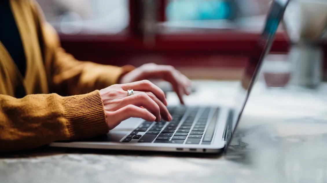 Woman's hands typing on laptop