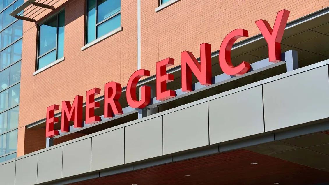 emergency sign wording in red on brick building