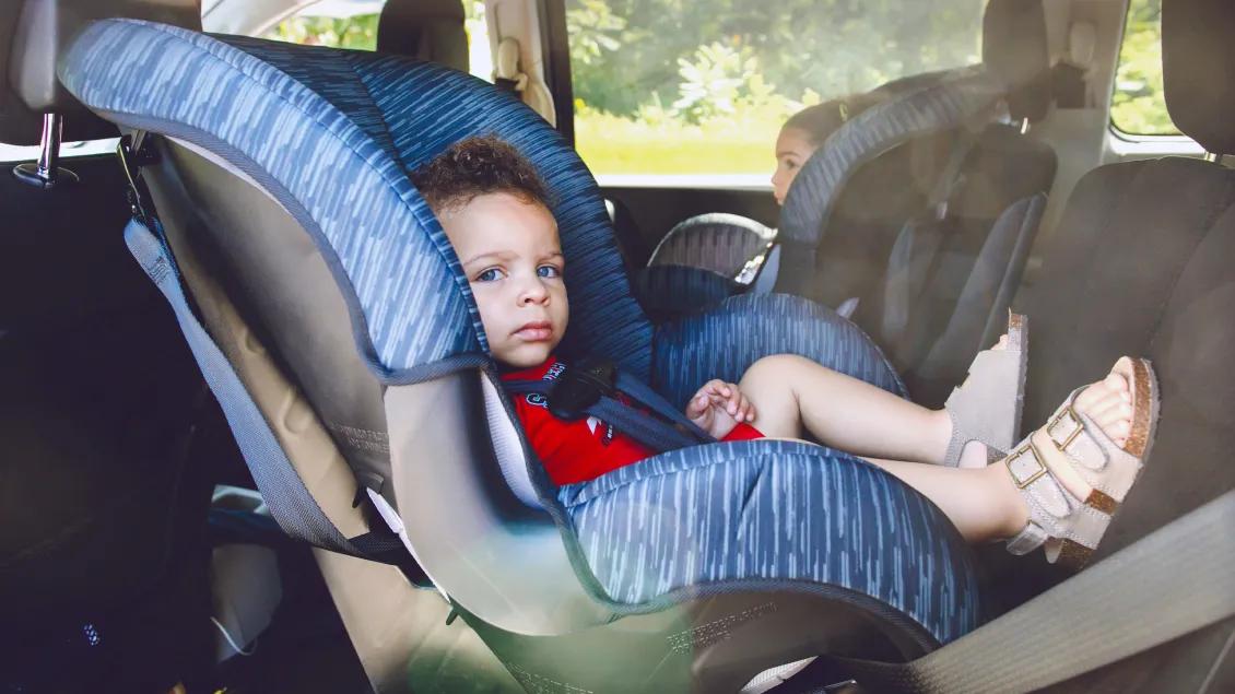 child in back seat of car in car seats