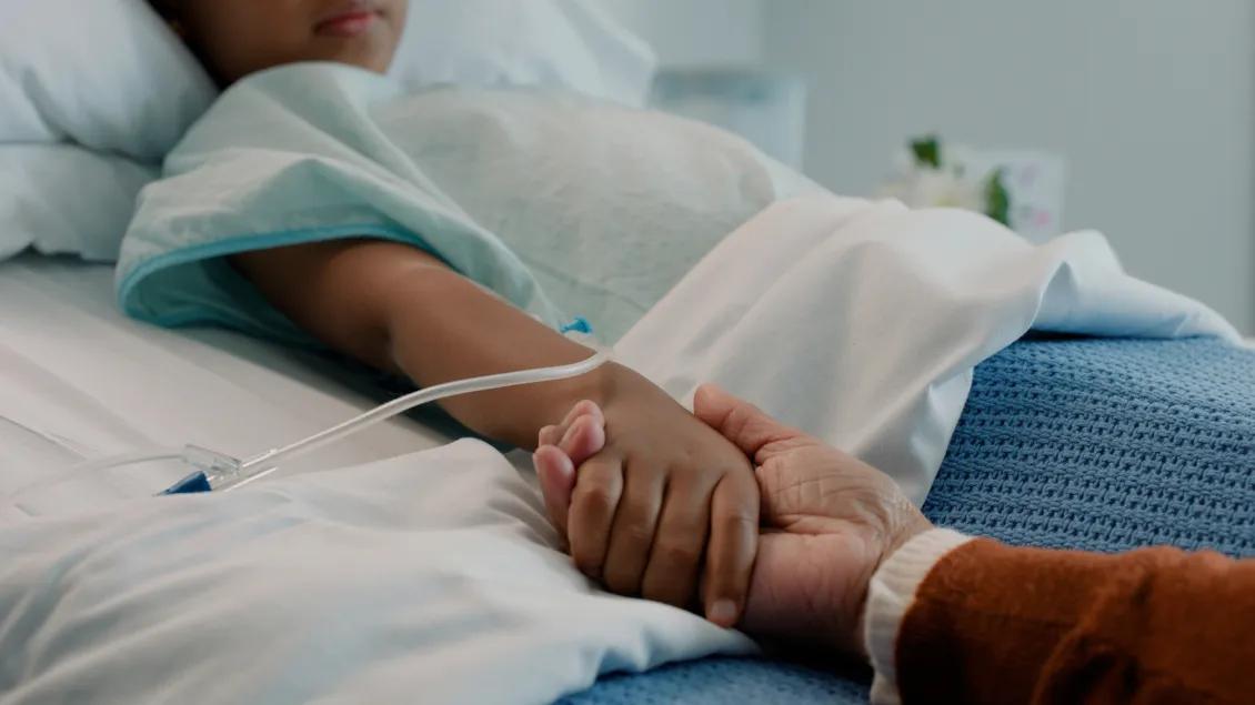 hand holding in bed child hopsital
