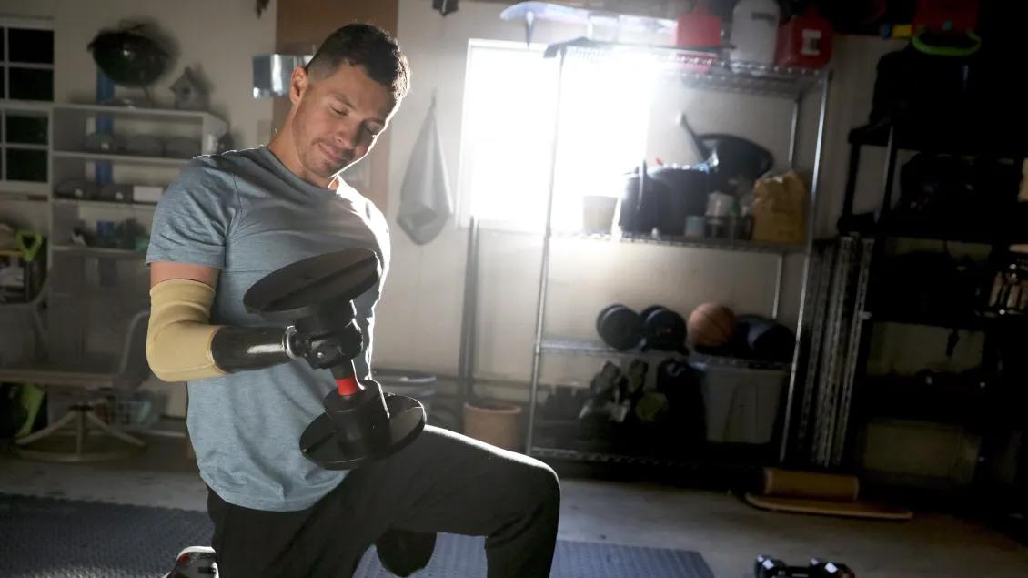 man lifting weight on knees in home gym