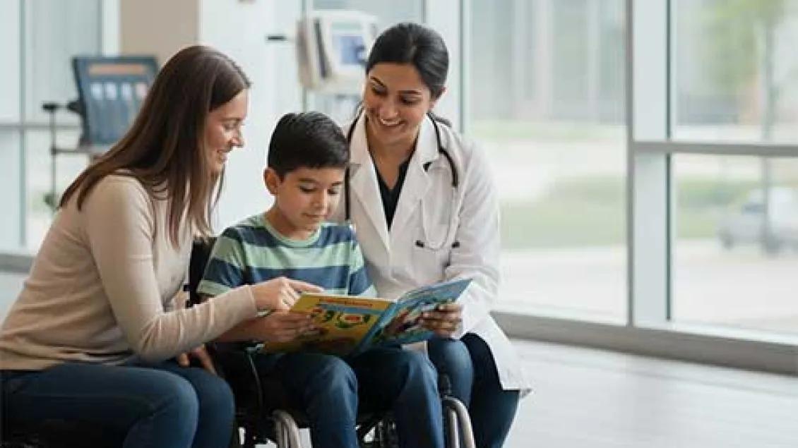 a mother, her son, and a doctor look at a magazine while smiling.