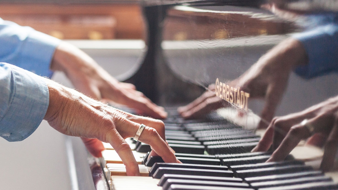 Close up of hands playing a piano