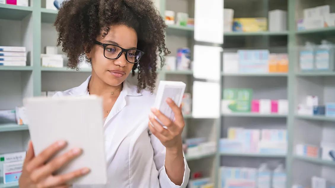 Person looking at a medication box with a tablet