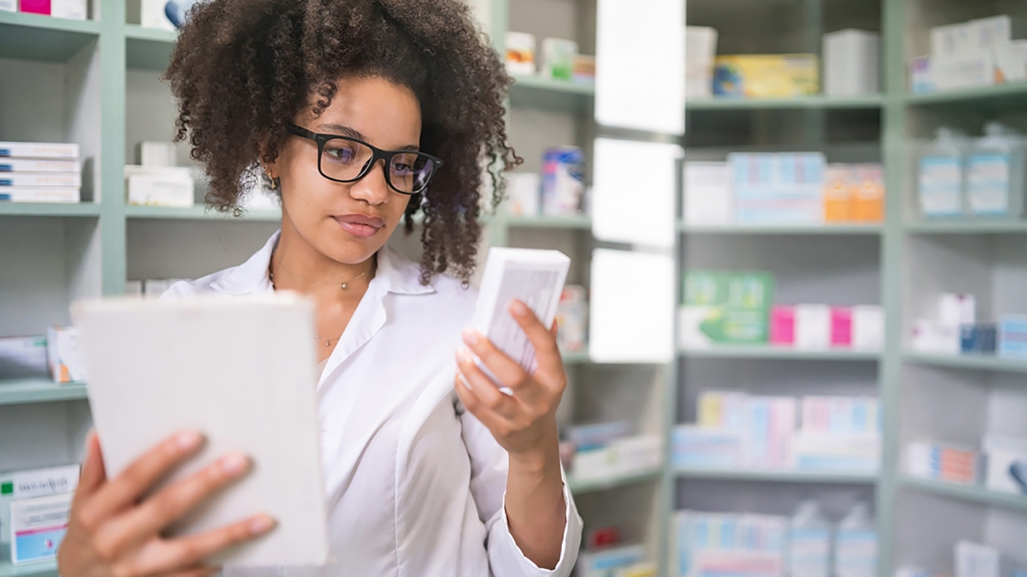 Person looking at a medication box with a tablet