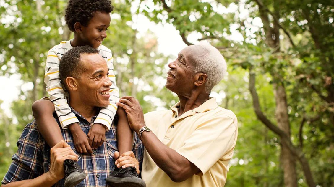Father has his son on his shoulders as the boy looks at his grandfather