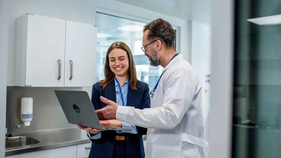 Medical professional and manager reviewing patient data in hospital.