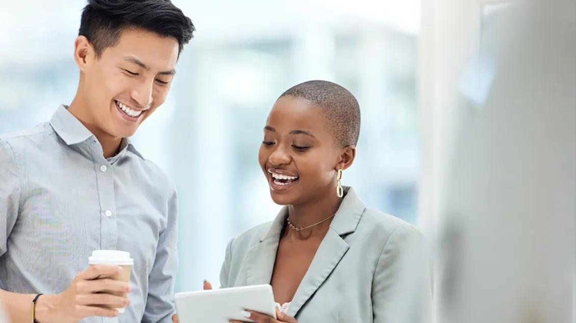 Two people talking and looking at tablet screen. 