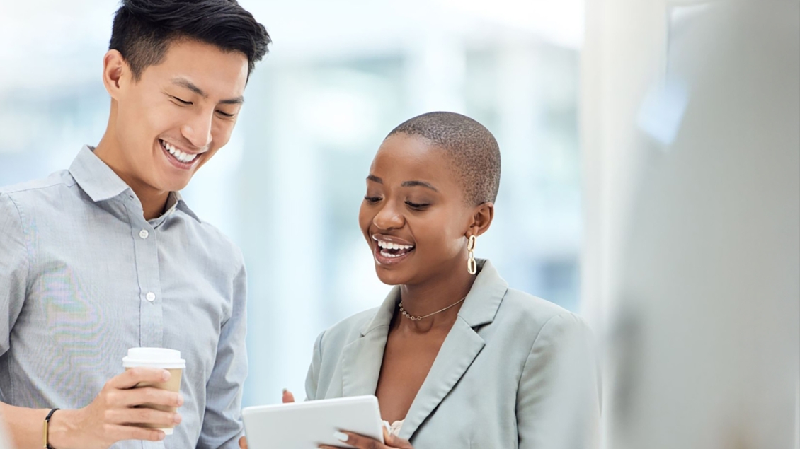 Two people talking and looking at tablet screen. 