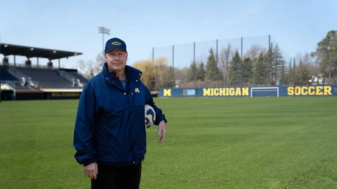 Steve Burns stands on the University of Michigan soccer practice field