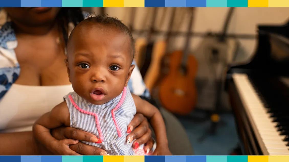 Baby on woman's lap looking into camera
