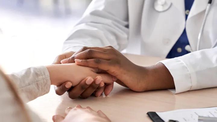 A doctor holding on to a person's hand