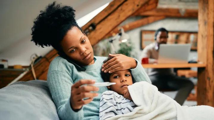 mom with sick child on phone checking tempature
