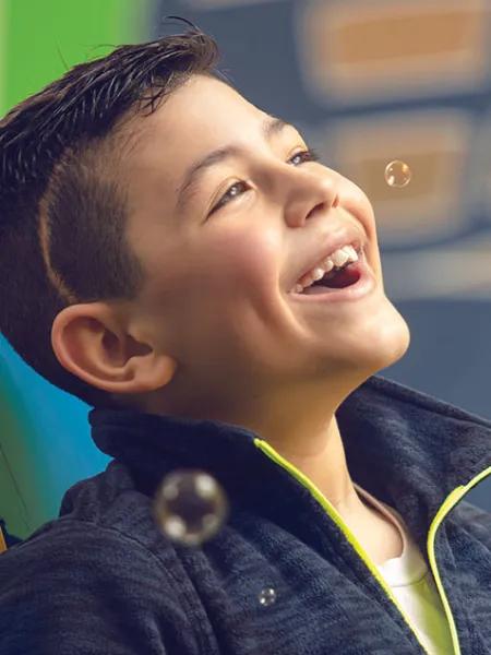 Dominic smiles while playing with bubbles
