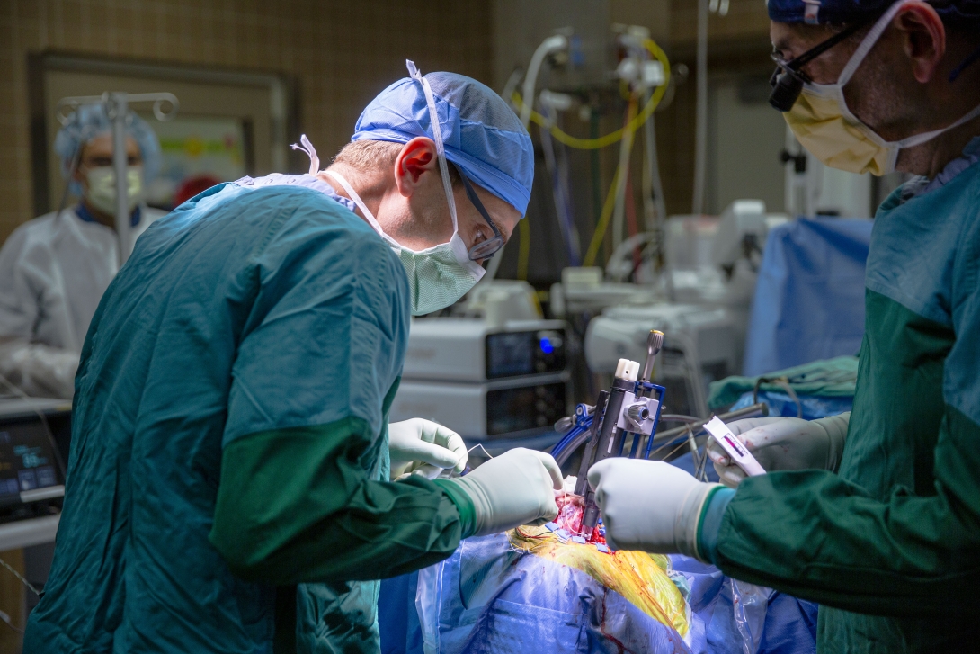 Dr. Matthew Willsey (left) lines up the cortical module inserter to be perpendicular to the surface of the brain as he and Dr. Oren Sagher (right) prepare of implantation of the device.