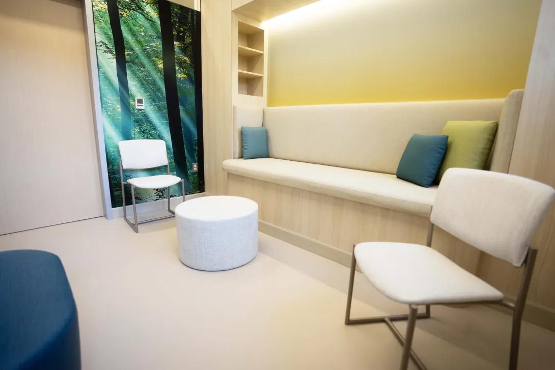 Small lounge area of clinic with white couch and chairs