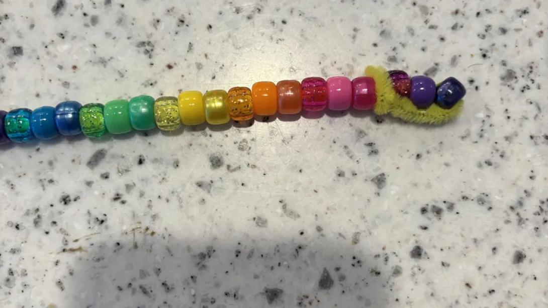 colorful beads line up on a pipe cleaner