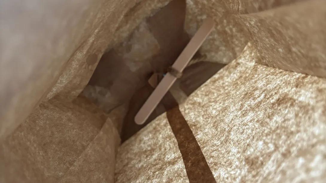 popsicle stick tied to bottom of paper bag
