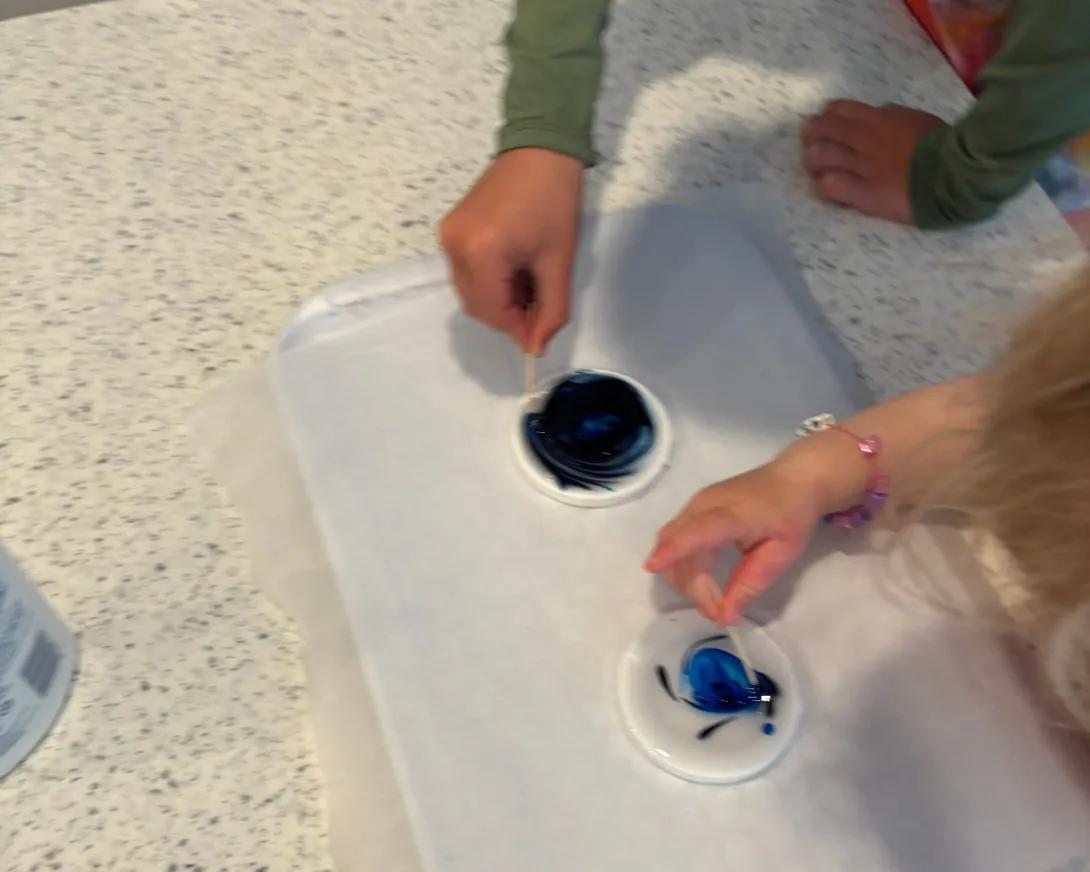 children using toothpicks to move color around glue circles